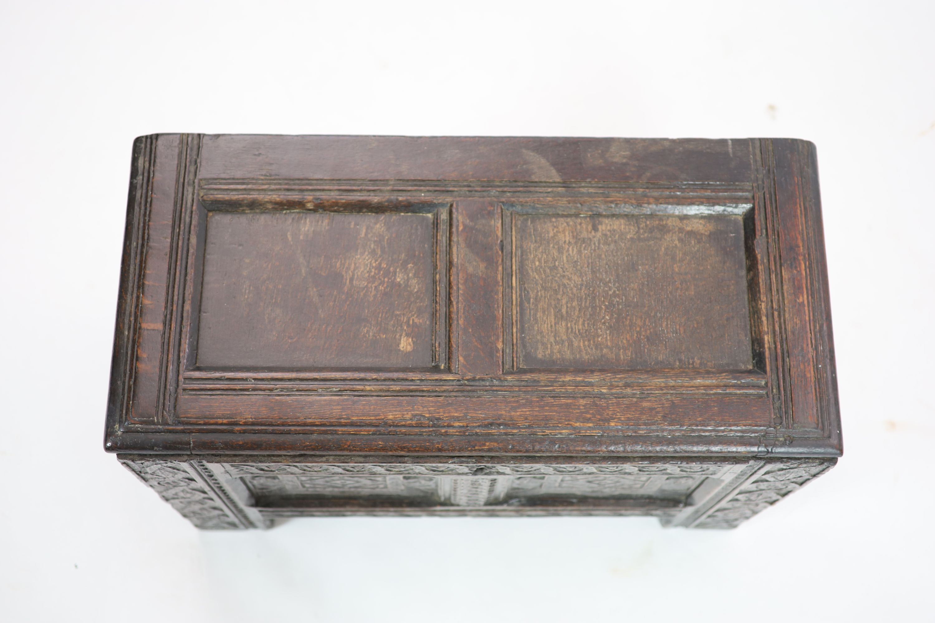 A late 17th/early 18th century small oak coffer (possibly West Country) the panelled front with Renaissance style carving H 46cm. W 70cm. D 34cm.